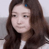 a close up of a girl with long hair making a funny face .