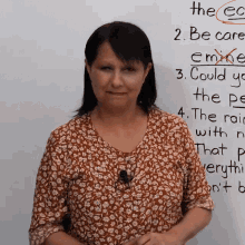 a woman is standing in front of a white board with the word the ec written on it