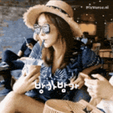 a woman wearing a hat and sunglasses is drinking from a cup with a straw