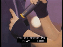 a person holding a microphone with a tcr 01 : 03 : 20 : 23 play lock