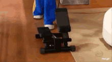 a person is using a stepper on a hardwood floor .