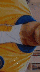 a blurry picture of a person wearing a yellow shirt with a blue circle that says ' mexico ' on it