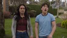 a man and a woman are standing in a yard with their mouths wide open