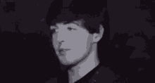 a black and white photo of a man with his eyes closed and his mouth open .