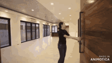 a woman opens a wooden door in an empty room made in animotica