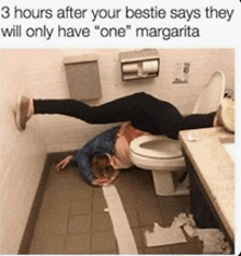 a woman is laying on the floor in a bathroom next to a toilet