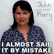 a woman standing in front of a white board with the name john mary written on it