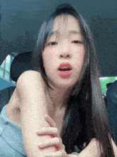 a woman with long hair is sitting in the back seat of a car and looking at the camera .