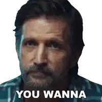 a man with a beard says " you wanna " in front of his face