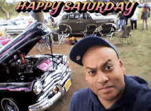 a man taking a selfie in front of a car with the words happy saturday behind him