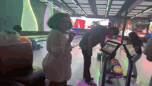a group of people are playing bowling at a bowling alley and one of them is looking at a tablet