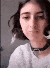 a close up of a woman 's face with a choker around her neck
