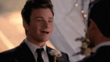 a man in a suit with a flower on his lapel