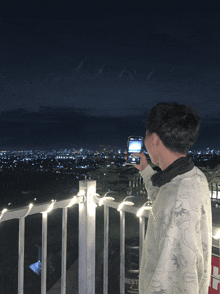 a man taking a picture of a city with his phone