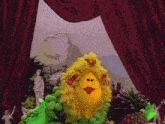 a yellow stuffed animal with flowers on it stands in front of a red curtain with a statue in the background