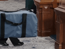 a person carrying a blue bag in a room