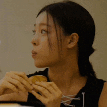 a woman in a black shirt has her eyes closed and her hands on her face