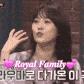 a woman is sitting in front of a brick wall and the words royal family are on the bottom of the image .