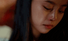 a close up of a woman 's face with tears running down her cheeks .