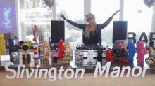 a woman is standing in front of a table with the words slivington manor written on it