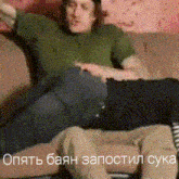 a man in a green shirt is sitting on a couch with his arms outstretched