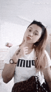a girl wearing a white shirt that says " mu " on it