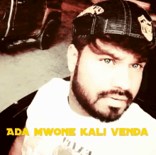 a man with a beard wearing a hat with the words ada mwone kali venda written on it