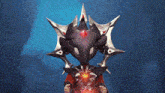 a cartoon character is wearing a crown with a red crystal in the center .