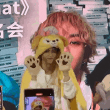 a person wearing a teddy bear hat is holding a phone