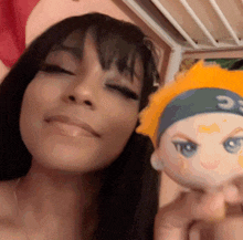 a woman is holding a stuffed doll with the letter c on his head
