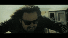 a man wearing sunglasses and a black jacket