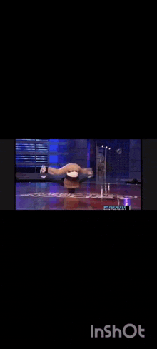 a person is doing a handstand on a stage in a video that says inshot