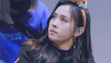 a woman wearing a headband with a stuffed animal on it is looking at the camera .