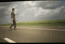 a man in a suit walks down the road