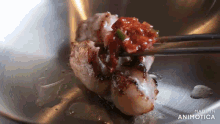 a close up of a plate of food with chopsticks and the words made in animotica