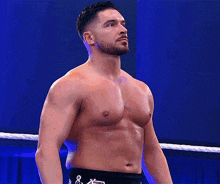 a man without a shirt is standing in a boxing ring