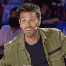 a man wearing a green jacket that says " the mountain lake of antique and classic " on it