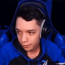 a young man wearing headphones is sitting in a blue chair .