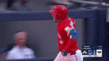 a baseball player wearing a red jersey that says blue jays is running on the field