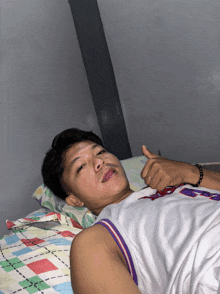 a man laying on a bed wearing a jersey that says ' nba ' on it