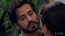 a man and a woman are hugging each other and the woman is wearing a wedding ring on her finger .