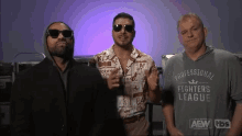 a man wearing a professional fighters league shirt is standing with two other men