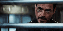 a close up of a man 's face behind bars