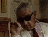 a man wearing sunglasses has a lady channel sticker on his chest