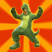 a person in a green dinosaur costume is dancing with their arms outstretched