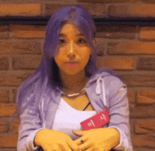 a woman with purple hair is wearing a name tag that says 이 사