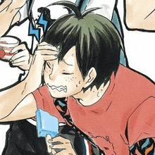 a boy is holding an ice cream cone in his hand and covering his forehead with his hand .