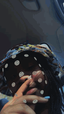 a person with smiley faces on their face wearing a hat