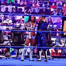 a woman in a wrestling ring holds a trophy and talks to another wrestler