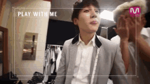a man in a suit and white shirt with the words play with me on the bottom